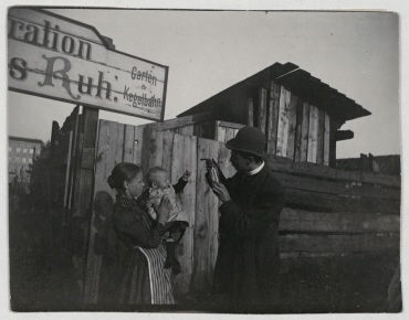 Young woman with child and a man in front of a "restaurant", summer 1897